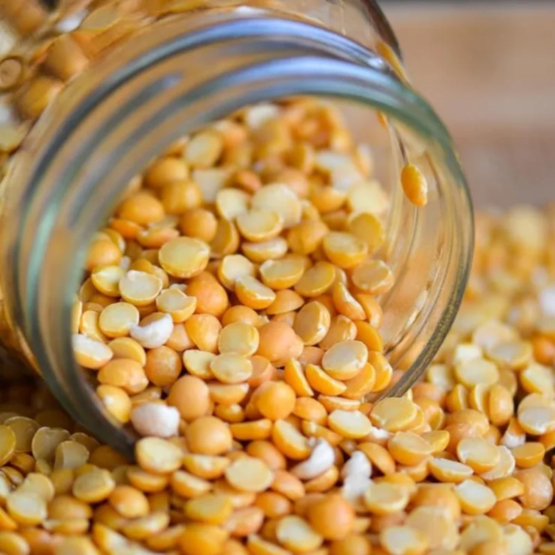Golden dal spilling from a glass jar, ready for badi